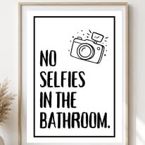 Black and white print reading No selfies in the bathroom with a camera doodle
