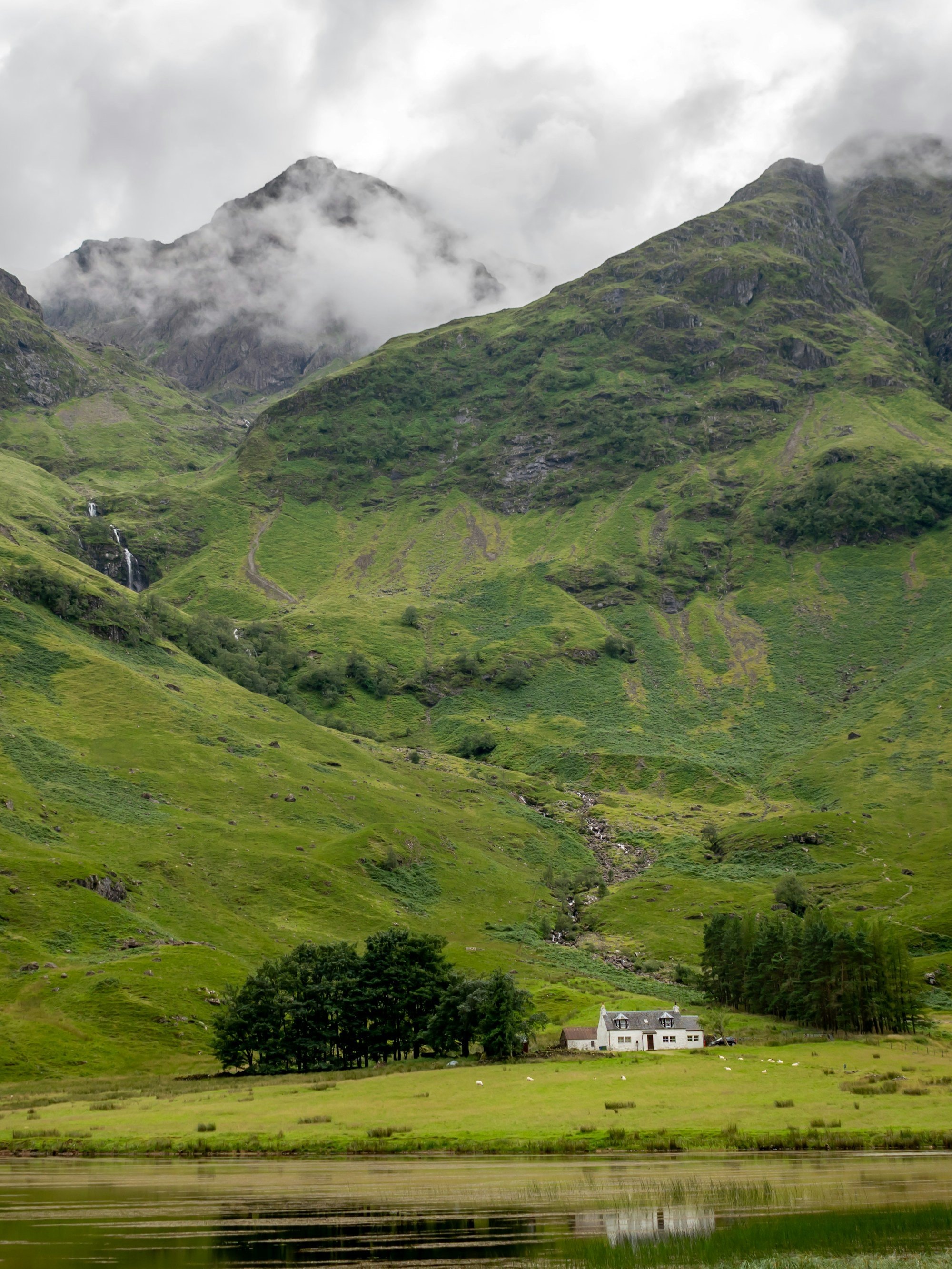 Green mountains under low white cloud